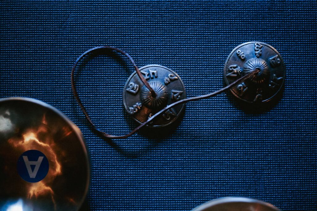 Tibetan tingsha cymbals resting on a blue mat, embodying spirituality and tranquility.